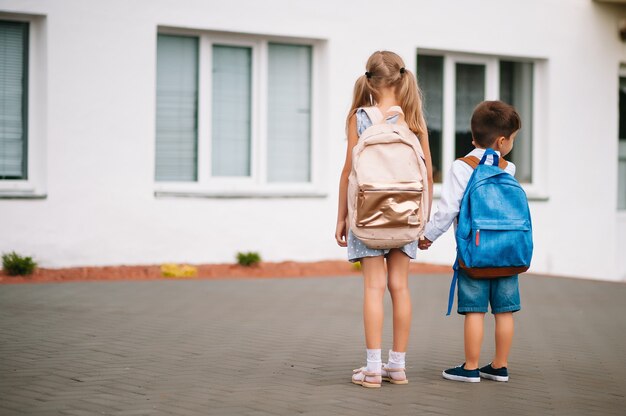 Foto dos amiguitos van a la escuela. niños de escuela. de vuelta a la escuela