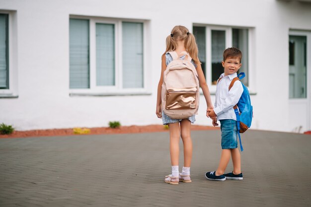 Dos amiguitos van a la escuela. Niños de escuela. De vuelta a la escuela