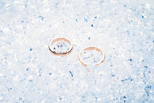 Dos anillos de boda dorados sobre hielo