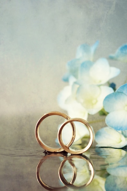 Dos anillos de boda y flores.