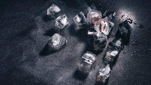 Foto dos anillos de boda en hielo sobre un fondo negro con humo