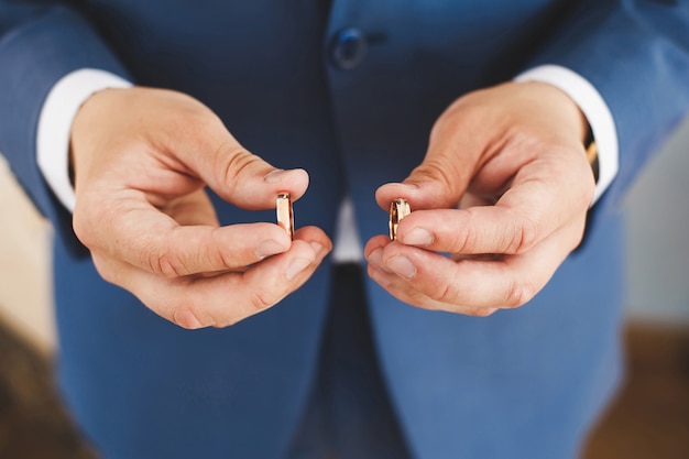 Dos anillos de boda en una mano del novio