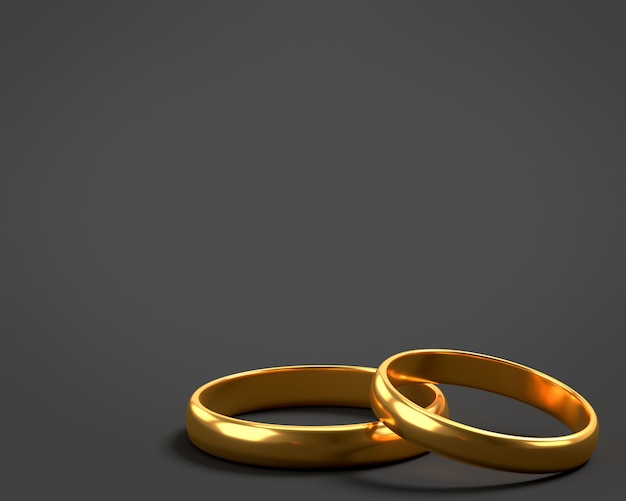 Dos anillos de boda de oro se encuentran uno sobre el otro con un espacio en blanco para el texto