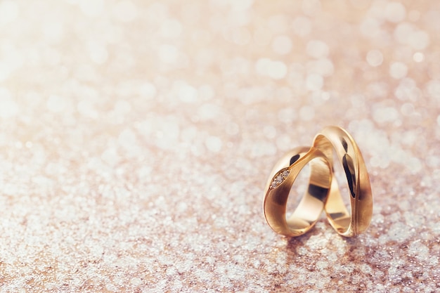 Dos anillos de boda sobre fondo abstracto con espacio de copia