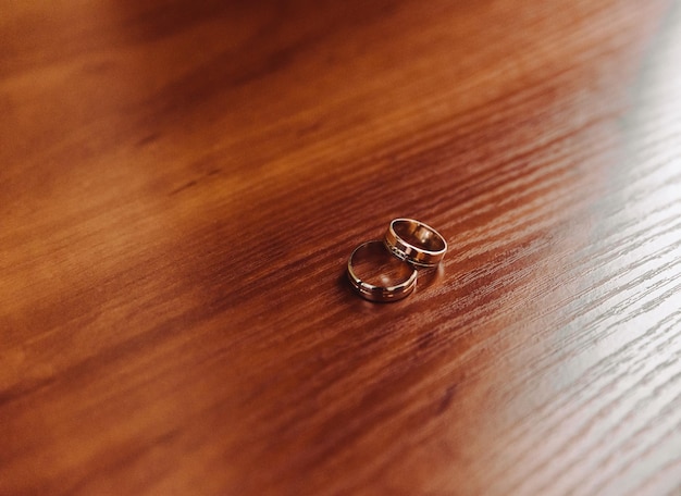 Dos anillos de boda en el suelo con contraste.