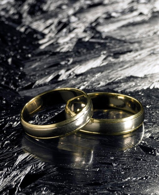 Foto dos anillos de bodas dorados en la superficie de hielo