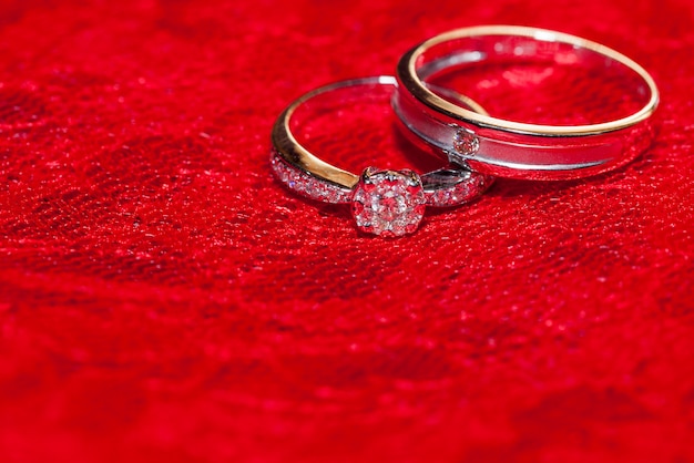 Dos anillos en seda roja para ceremonia de boda.