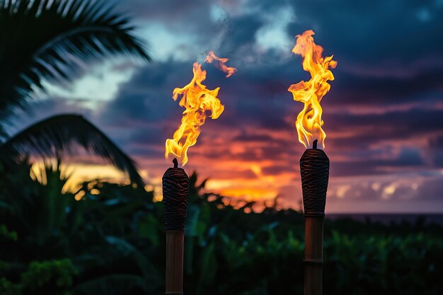 Dos antorchas tiki con llamas ardiendo al atardecer en Hawai