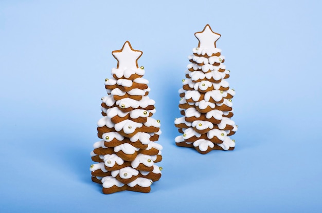 Dos árboles de navidad de pan de jengibre aislados sobre fondo azul Concepto de año nuevo y feliz navidad