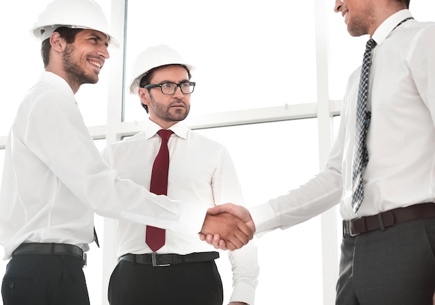 Dos arquitectos dándose la mano después de una reunión en el cargo