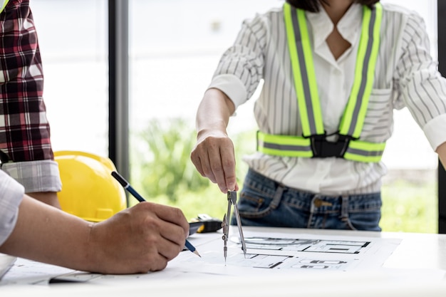 Dos arquitectos-ingenieros están consultando para modificar los planos de la casa contratada, tienen una reunión para inspeccionar los diseños de la casa antes de reunirse con el cliente. Ideas de diseño para el hogar.