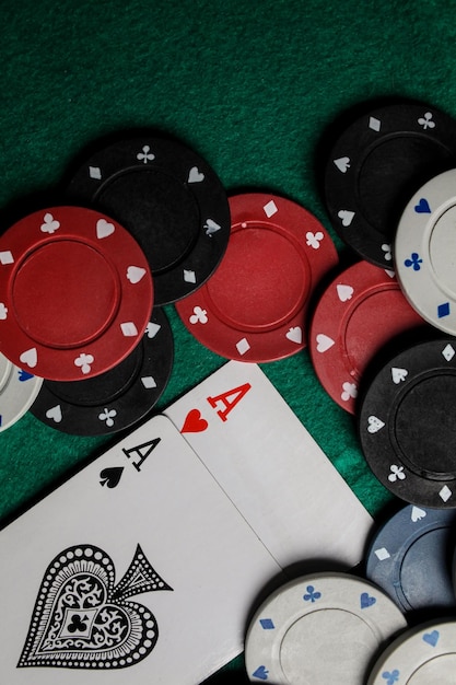 dos ases en la mesa de juego verde. dos cartas de juego y fichas de póquer en una mesa de casino verde.