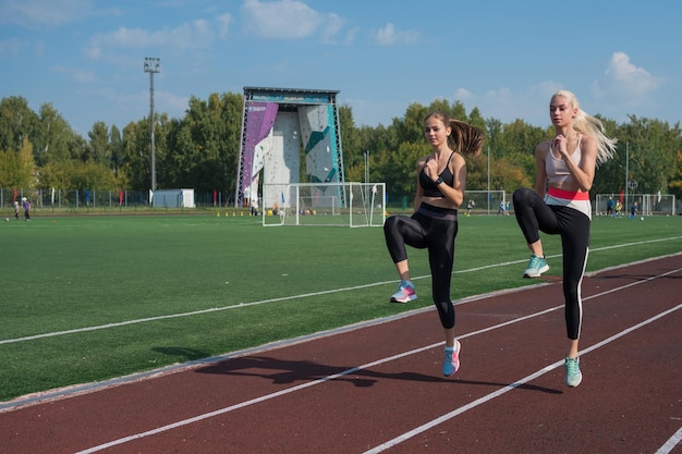 Dos atletas jóvenes runner están entrenando en el estadio al aire libre