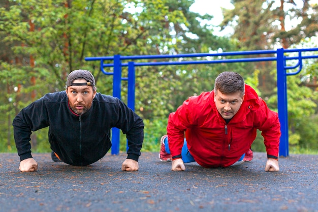 Dos atletas de mediana edad haciendo flexiones