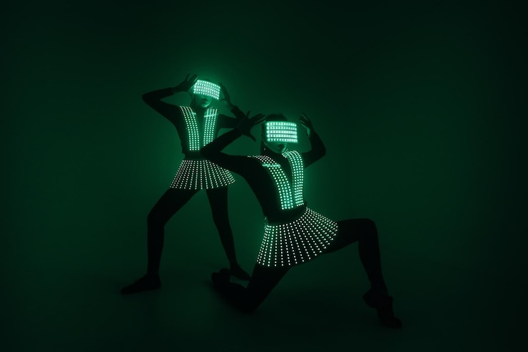Foto dos bailarinas de discoteca sexys se mueven con trajes uv. fiestas y bailes.