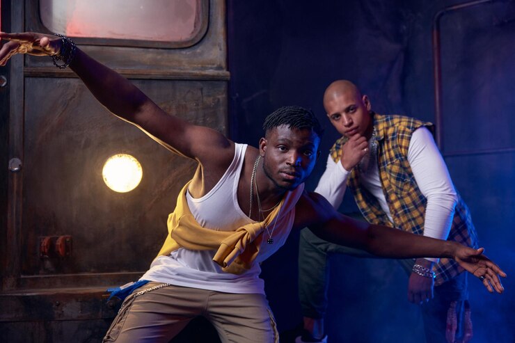 Foto dos bailarines modernos de hip hop en un garaje realizando un baile urbano de estilo libre