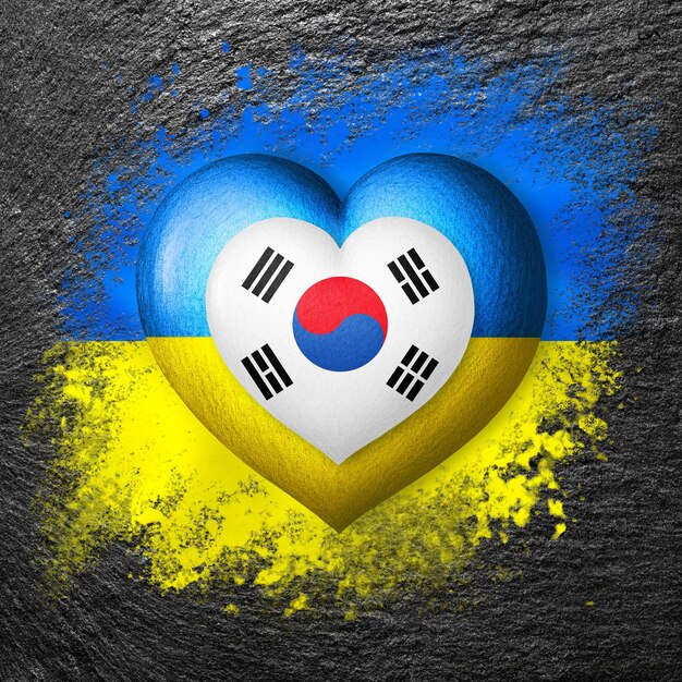 Dos banderas Banderas de Ucrania y Corea del Sur Dos corazones en los colores de las banderas son pintura sobre piedra