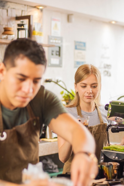 Dos baristas haciendo café en una máquina.