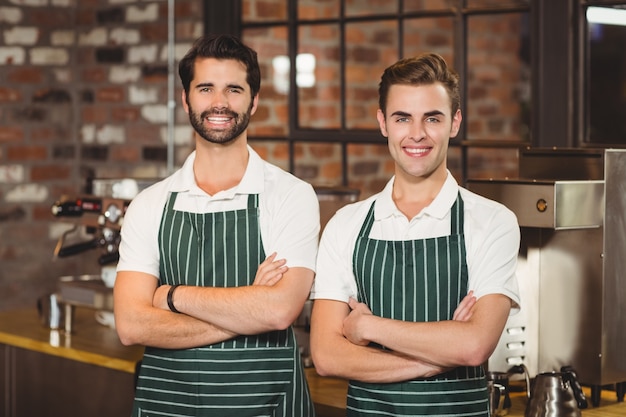 Dos baristas sonrientes mirando la cámara