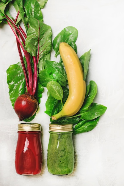 Dos batidos de desintoxicación veganos saludables con espinacas y remolacha verduras frescas dieta cruda concepto comida y bebida fondo plano