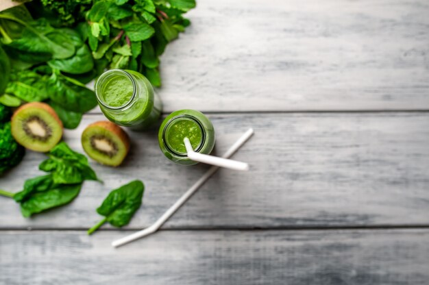 Dos batidos con verduras, aguacate, manzana, kiwi sobre un fondo de madera. nutrición deportiva