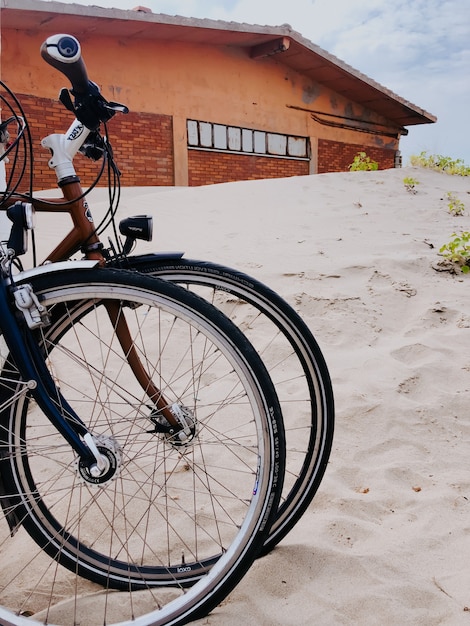 dos bicicletas deportivas se colocan una al lado de la otra playa de arena blanca. plantilla espacio libre patrón papel tapiz maqueta
