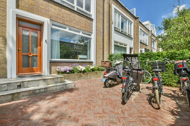 Dos bicicletas estacionadas afuera de una casa con un patio de ladrillos