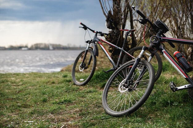 Dos bicicletas de montaña se paran en la orilla del río picnic ligero dinámico atmosférico