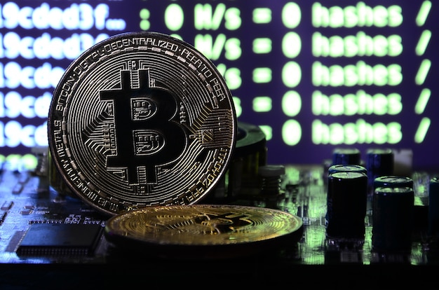 Dos bitcoins se encuentran en una superficie de tarjeta de video