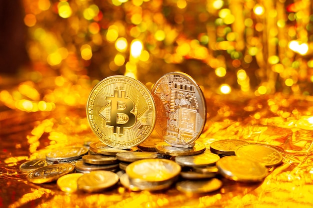 Dos bitcoins en una pila de monedas sobre un fondo dorado y un bokeh