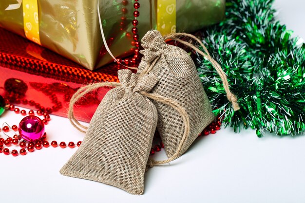 Dos bolsas de lona con corbatas Bolsas de lino en cajas de regalo y adornos navideños de fondo