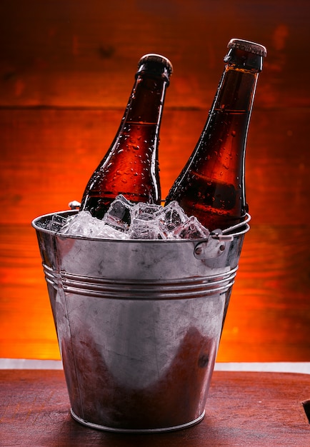 dos botellas de cerveza en un cubo de hielo