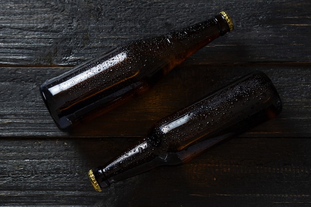 Dos botellas de cerveza en una mesa de madera. gotas sobre el vidrio