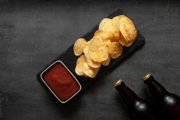 Dos botellas de cerveza con patatas fritas y salsa de tomate