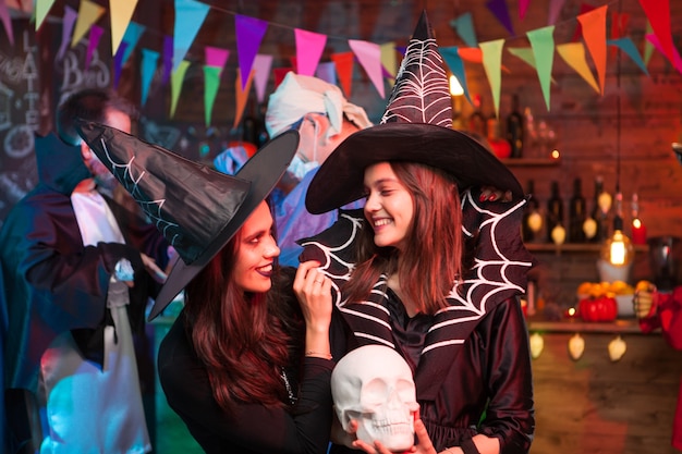 Foto dos brujas pasando un buen rato juntos en la fiesta de halloween. brujas celebrando halloween.