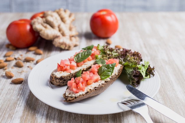 Dos bruschettas, jengibre y tomates.