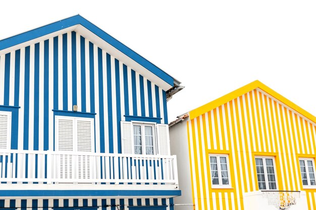 Dos cabañas a rayas de colores antiguos en un resort cerca del océano en Portugal Apartamentos Casas creativas Colores a rayas amarillas y azules