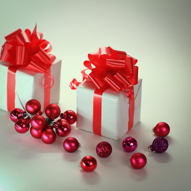 Dos cajas de regalo blancas y bolas de navidad aisladas en blanco