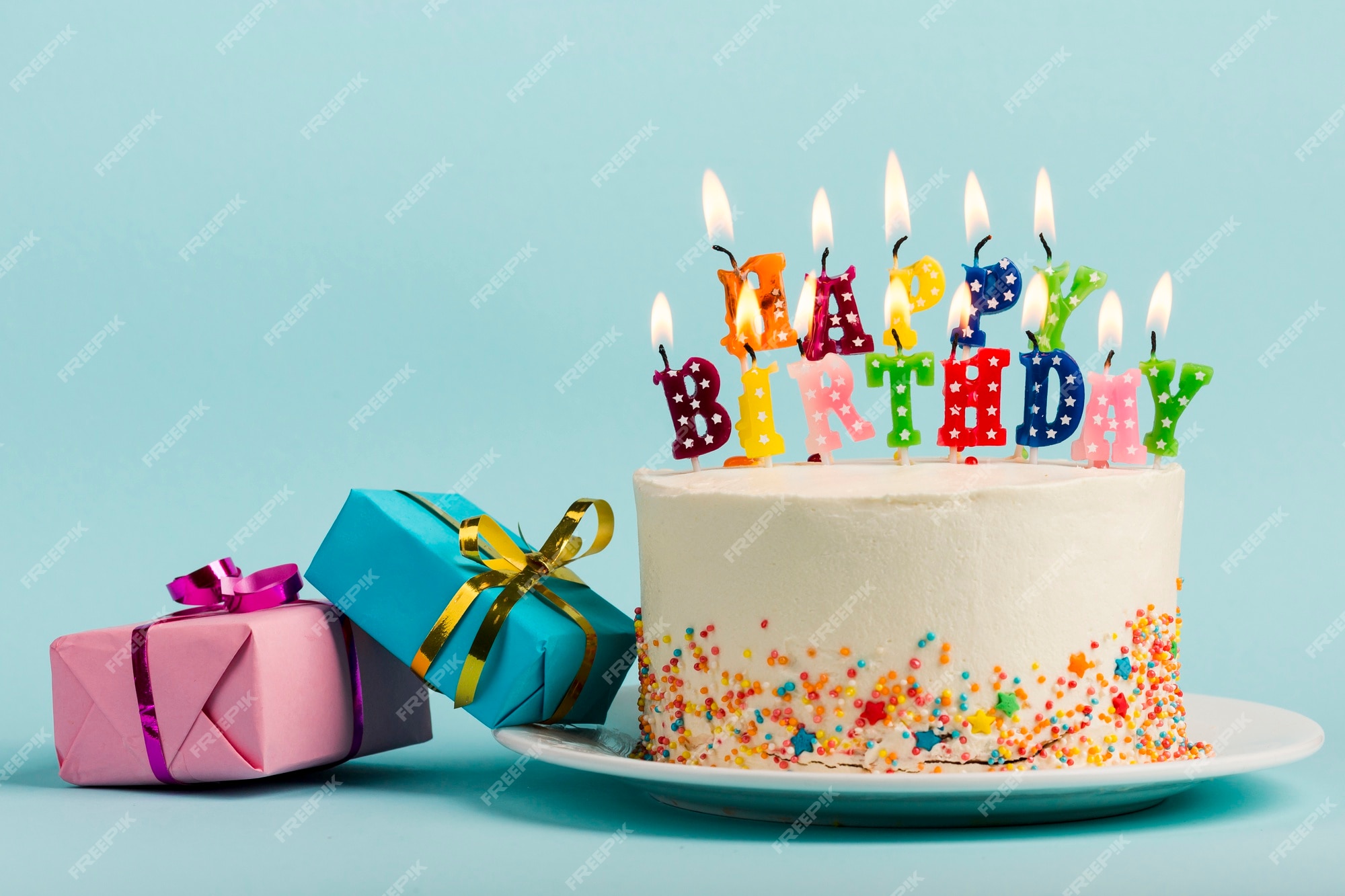 Dos cajas de regalo cerca de la torta con velas de feliz cumpleaños contra  el fondo azul | Foto Premium