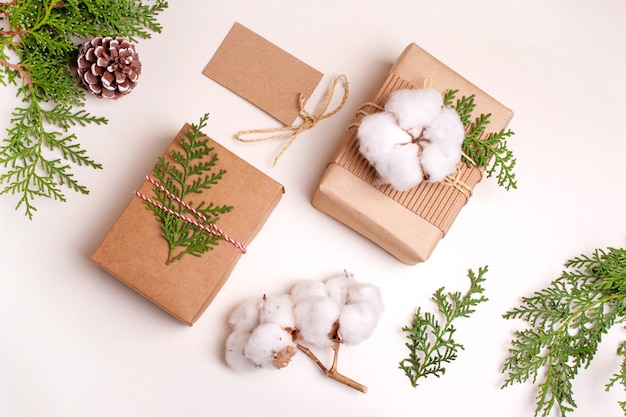 Foto dos cajas con regalos de navidad y ramitas de enebro. concepto de año nuevo. estilo plano