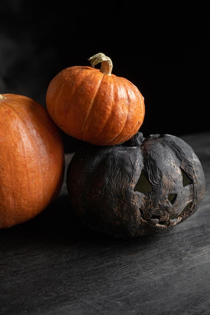 Dos calabazas naranjas y una calabaza negra de halloween.