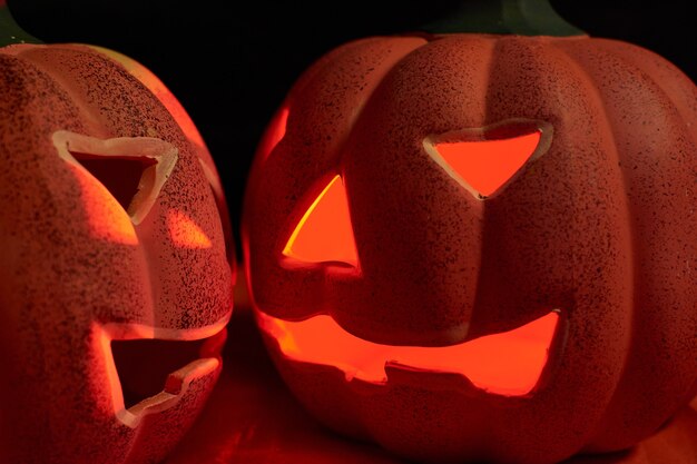 Dos calabazas talladas brillantes en un fondo oscuro - concepto de halloween