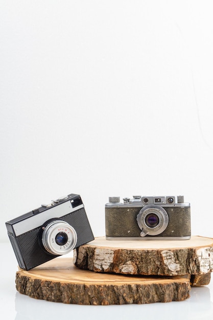 Dos cámaras de fotos retro en tableros de madera concepto de cámaras para hombres y mujeres tiro vertical aislado o