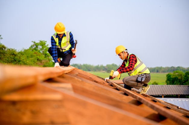 Dos carpinteros están trabajando en el sitio de construcción. Construcción de la estructura del techo de madera. Ideas para reformar y ampliar casas de madera.