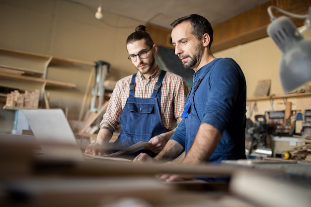 Dos carpinteros modernos trabajando en proyecto