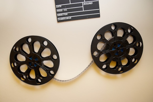 Dos carretes de película de cine retro con tablero de chapaleta en la pared