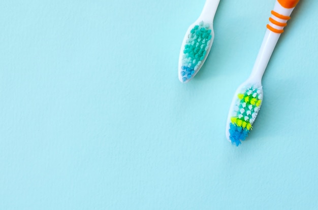 Dos cepillos de dientes se encuentran en azul pastel.