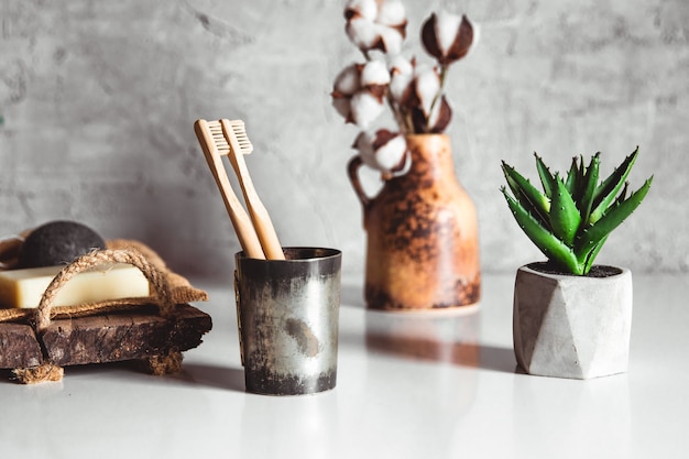 Dos cepillos de dientes de madera de bambú ecológico blanco y amarillo en madera con blanco