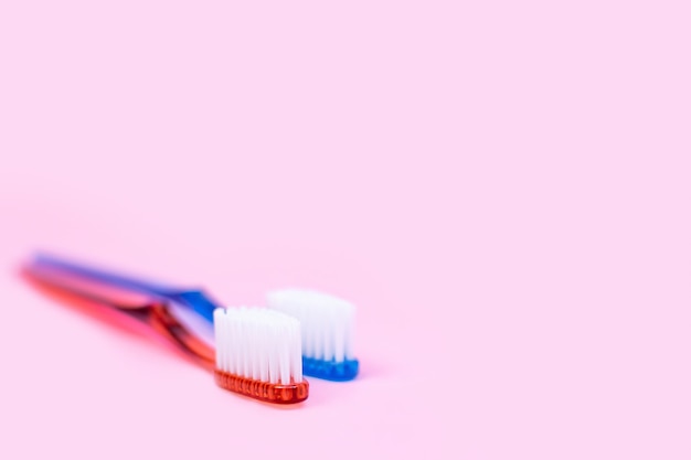 Foto dos cepillos de dientes en rosa, cepillos de higiene bucal personal para hombres y mujeres, rutina matutina para una pareja