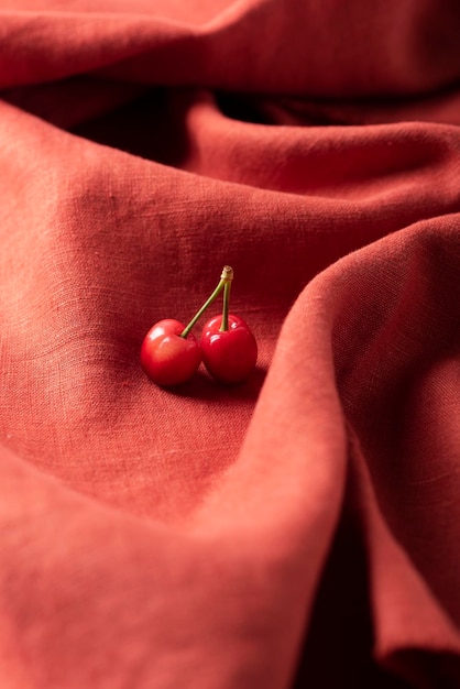 Dos cerezas en la tela de lino.